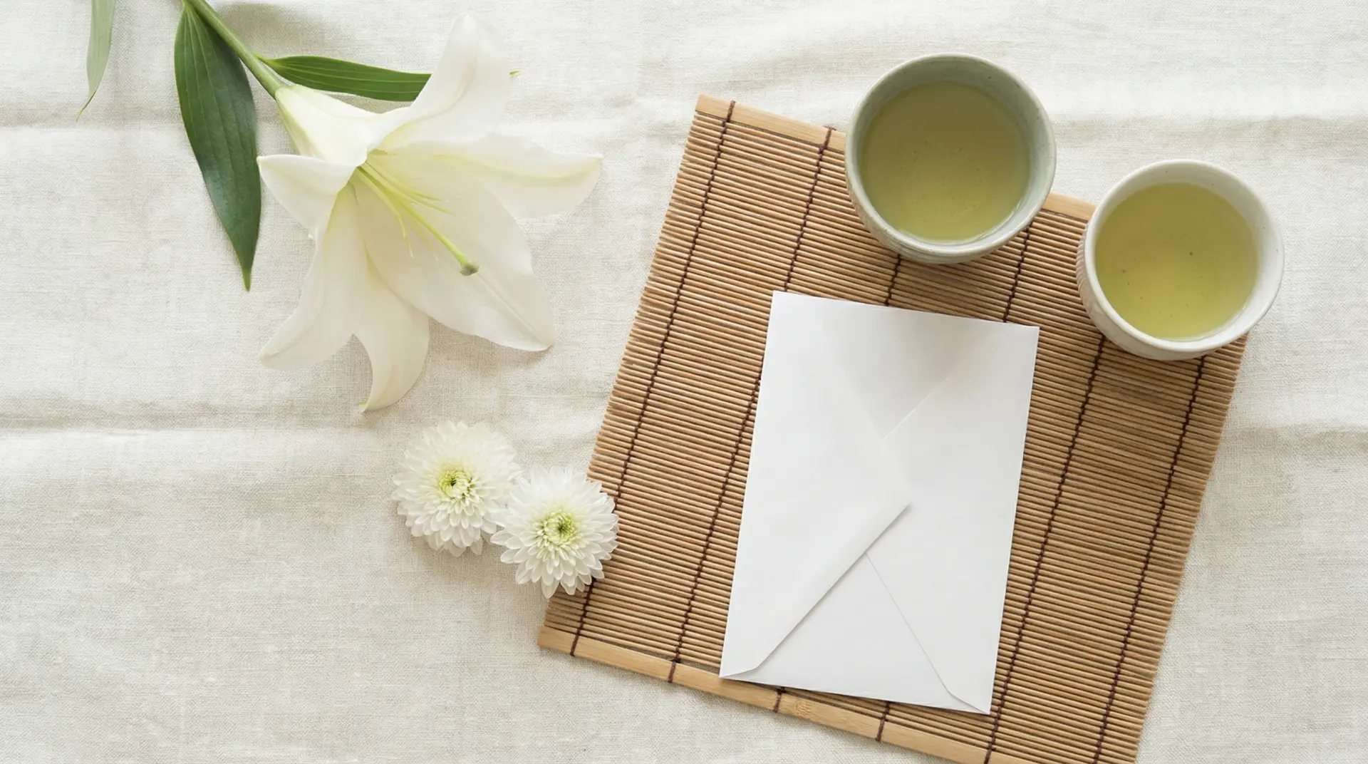 白いゆりと菊が一輪ずつ添えられた、静かな弔いの支度